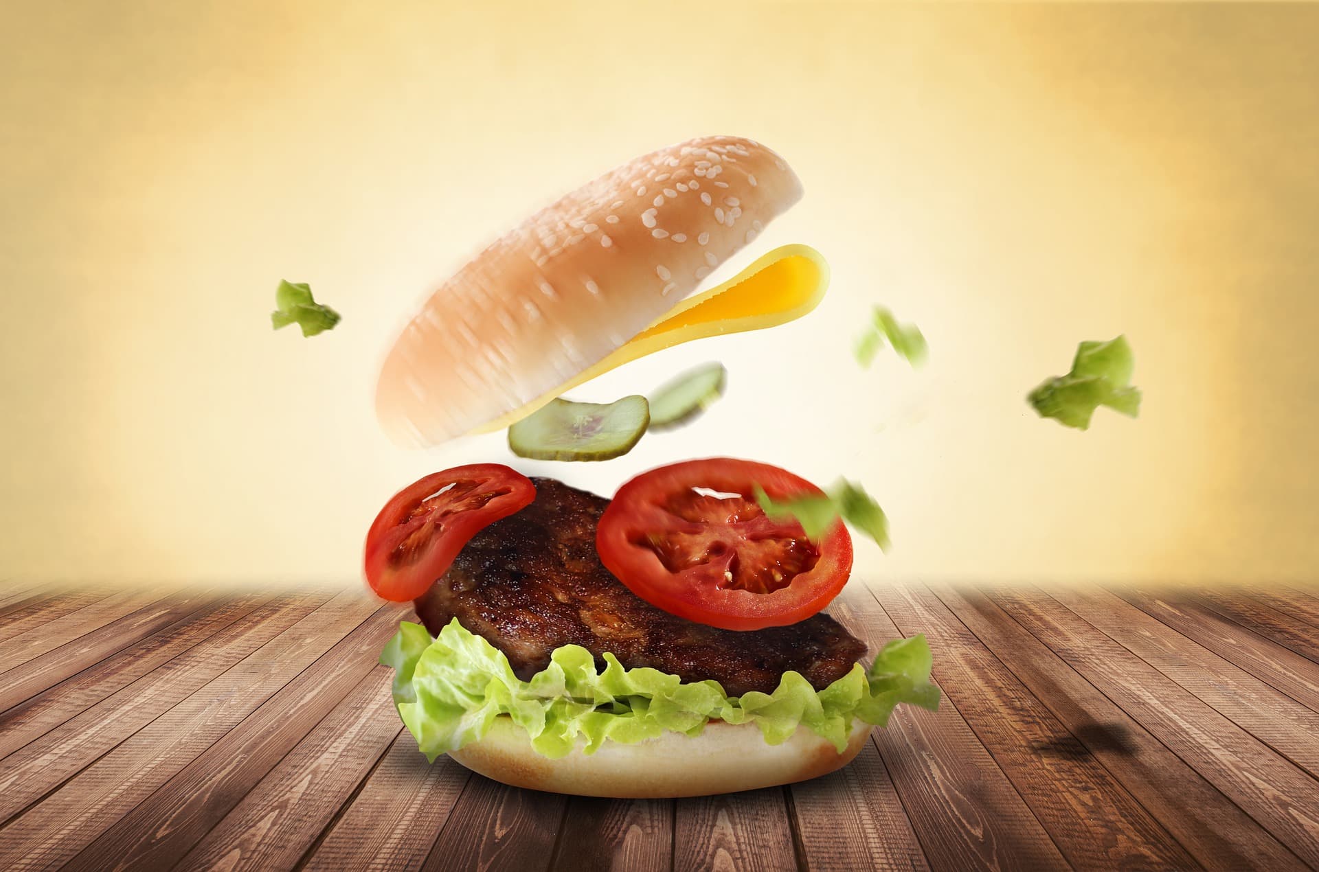Entstehung eines Hamburgers mit Frische Zutaten und eine frische Frikadelle fliegen in ein Burgerbrötchen Lieferservice Geesthacht